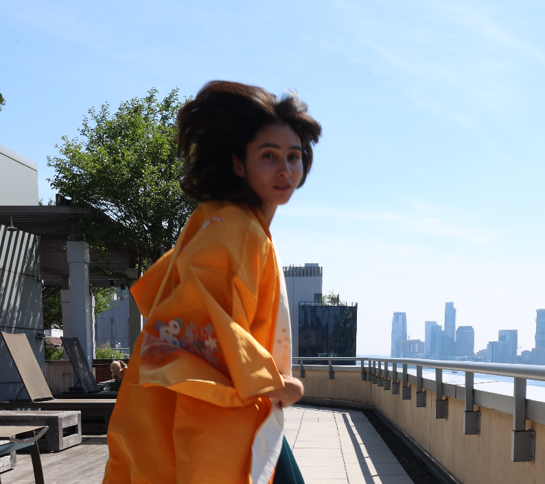 Dani wearing a formal golden kimono on a New York rooftop